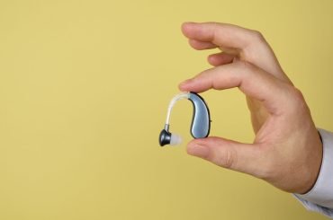 hand-holding-hearing-aids-with-copy-space